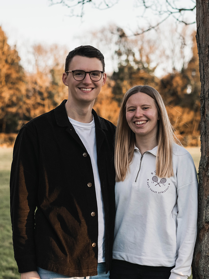 engaged couple in a park at sunset